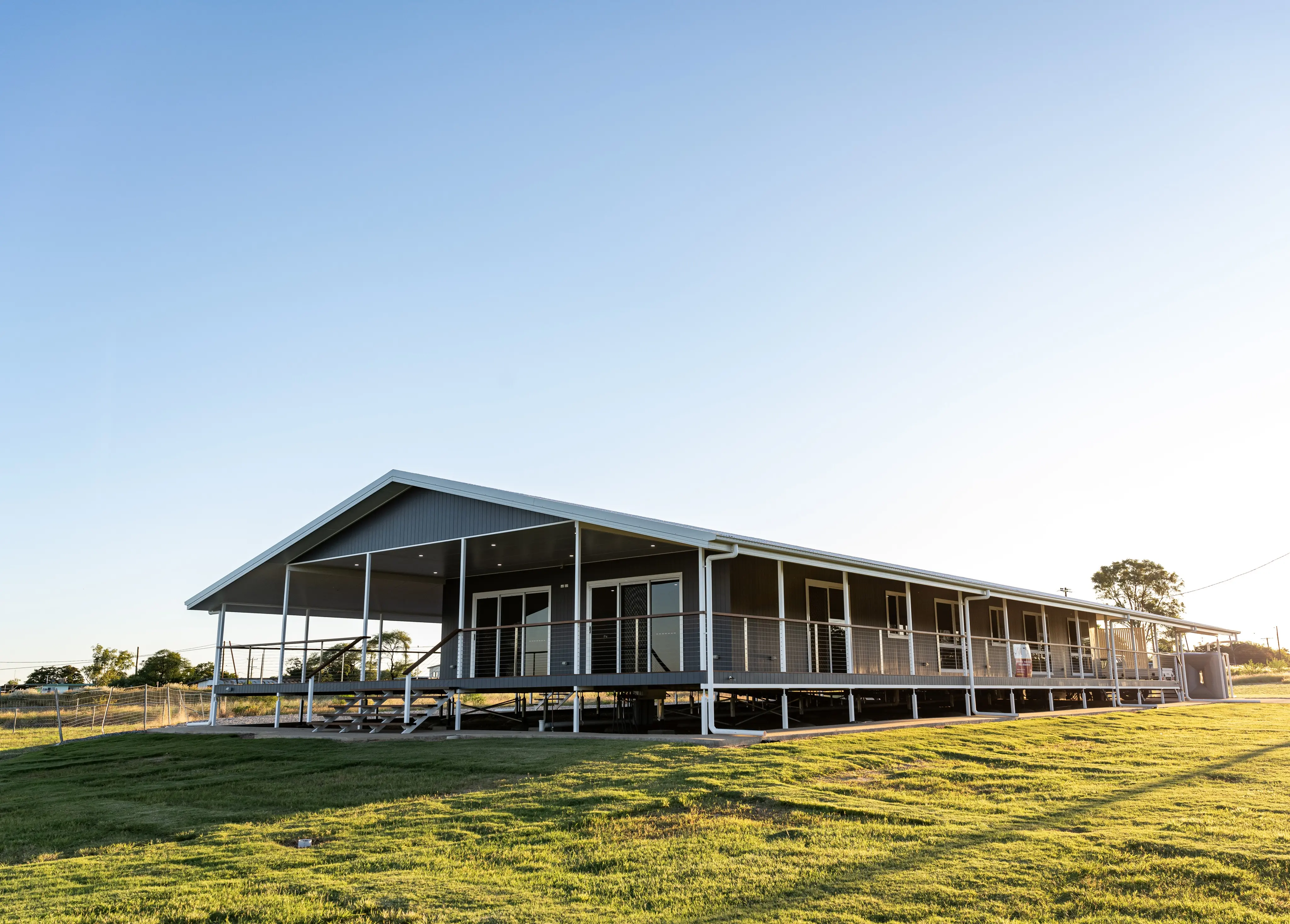A completed custom home at golden hour, seen across the lawn
