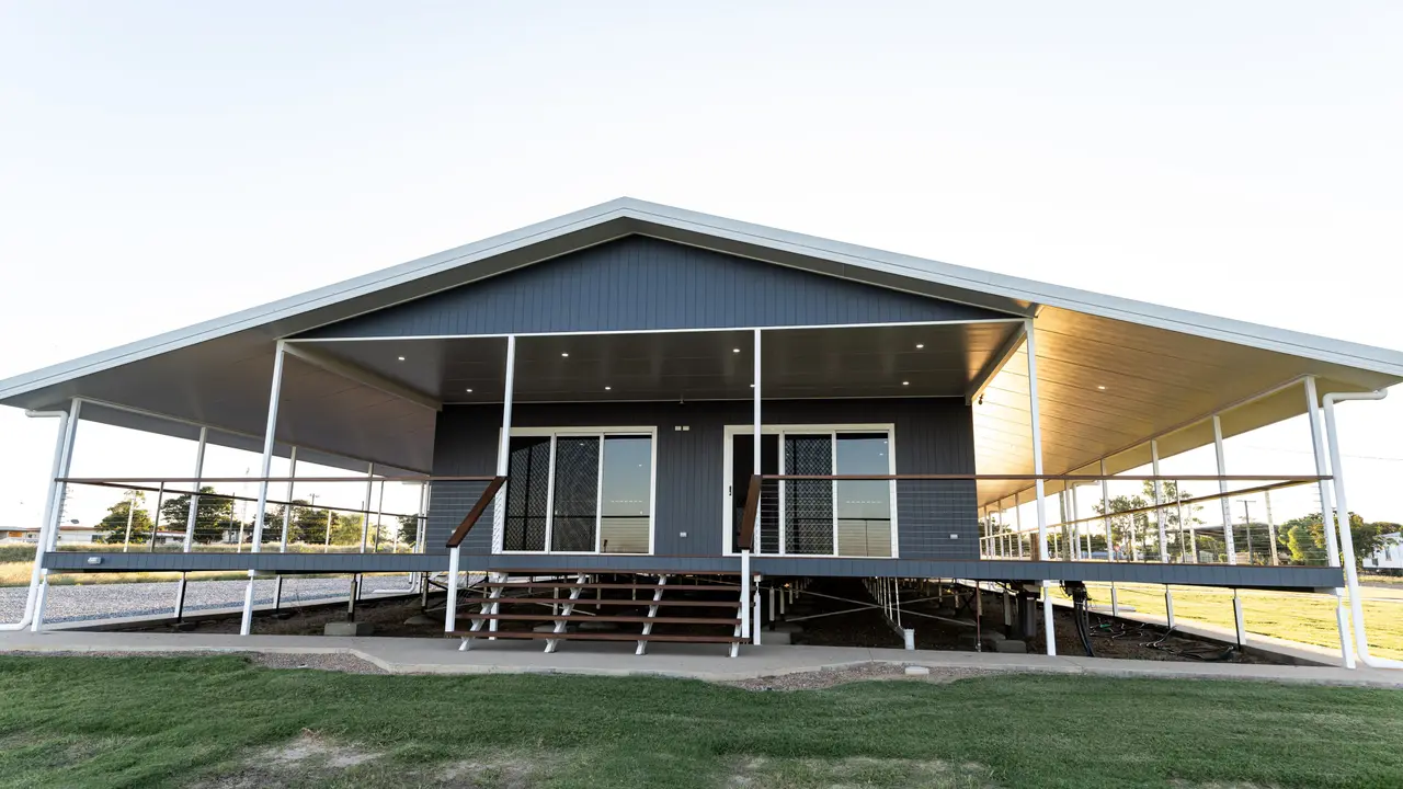 Front elevation of a custom home with light raking across the verandah soffit