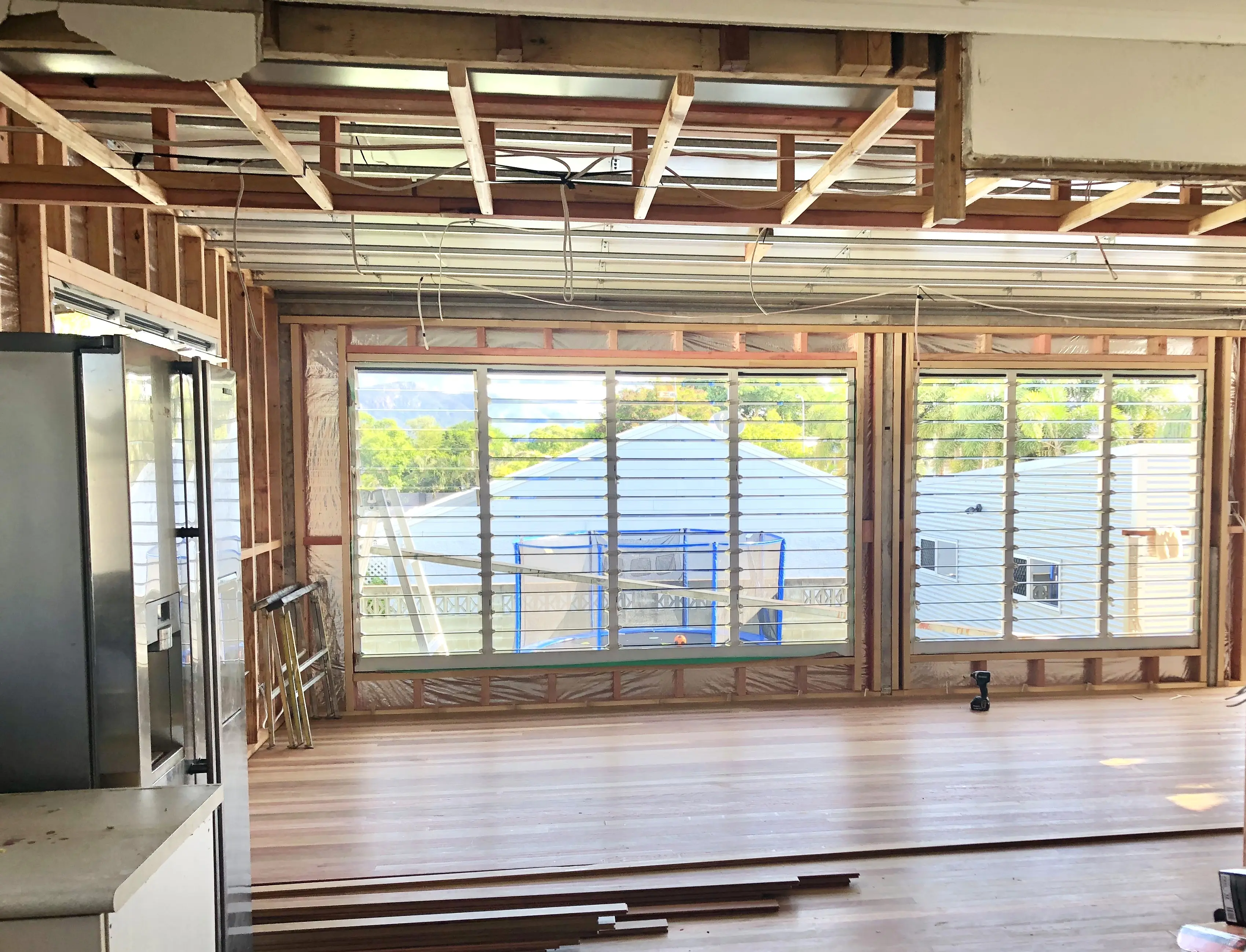 A living area stripped back to the timber frame with new louvres and steel roof battens installed