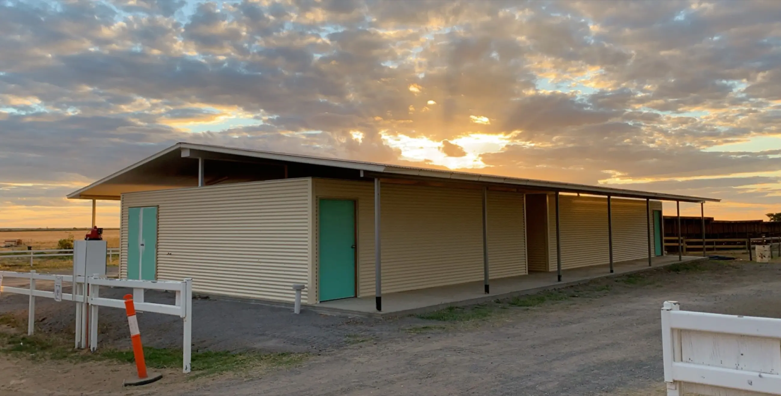 Completed racecourse amenities building beneath a warm western Queensland sunset