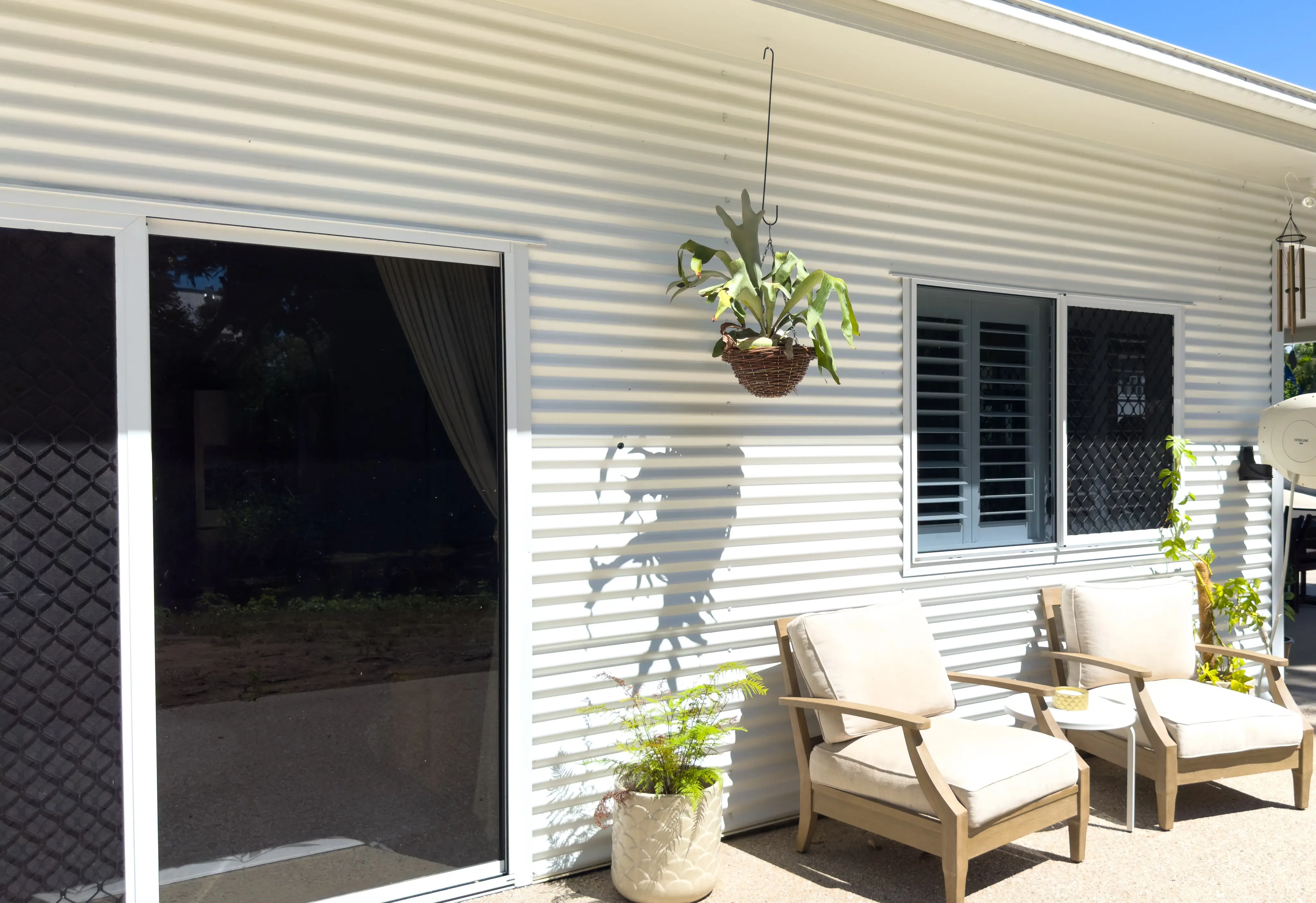A verandah corner set up with teak armchairs