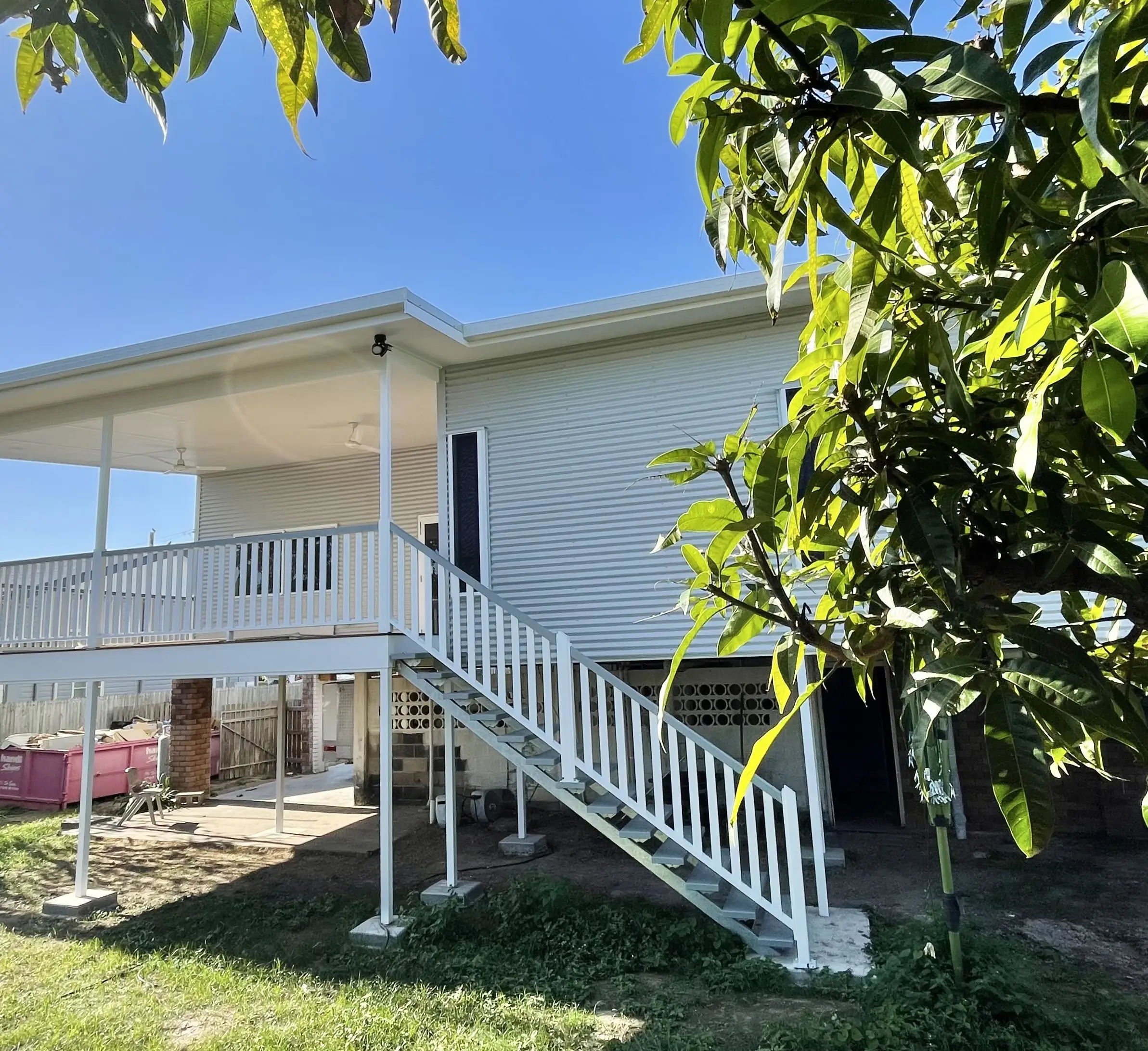 Rear elevation of a renovated home with a new deck on steel columns