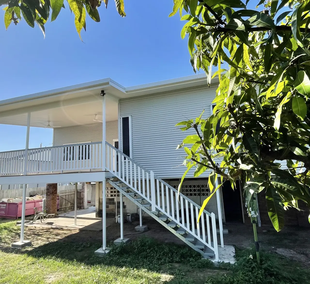 Rear elevation of a renovated home with a new deck on steel columns