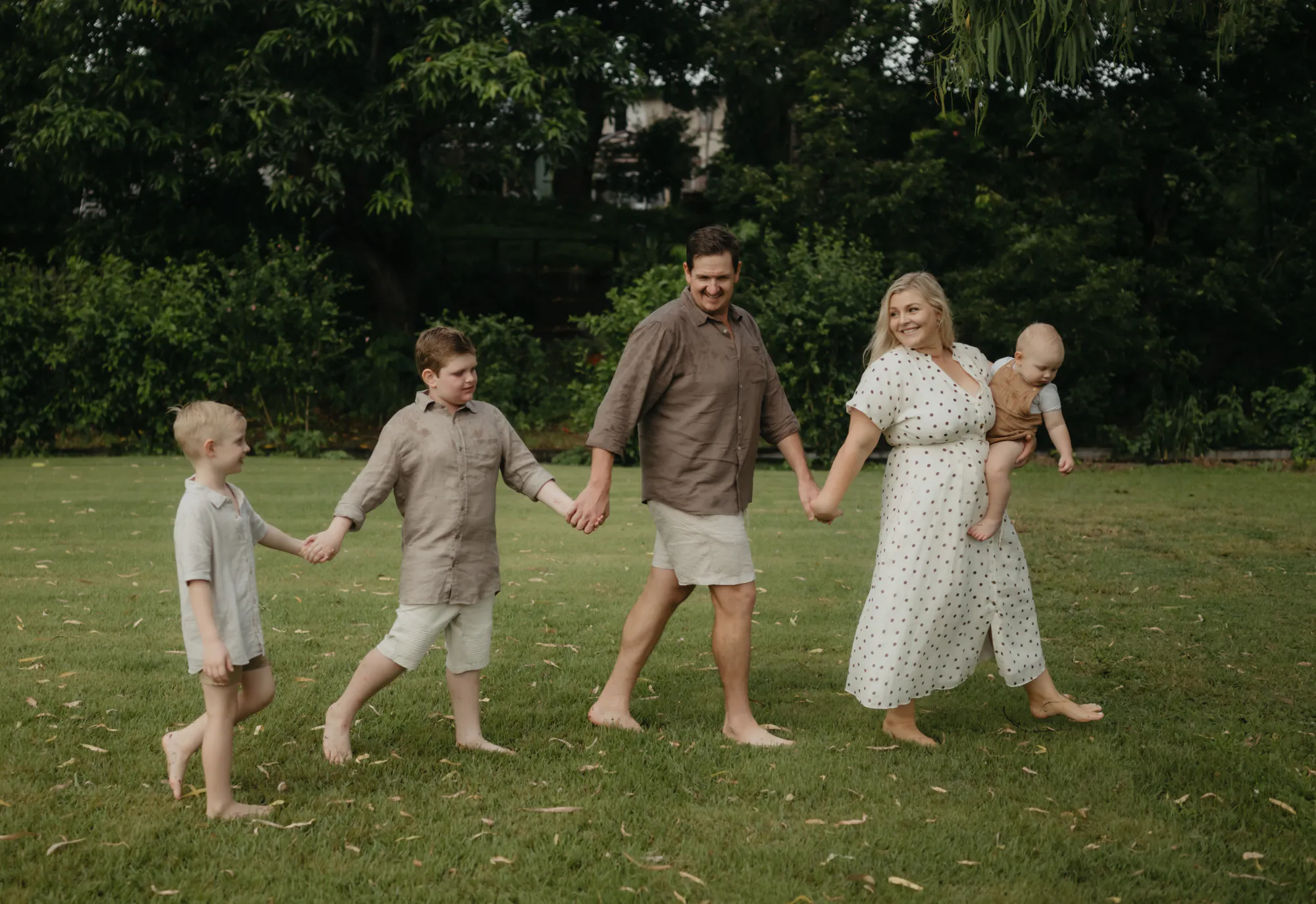 Patrick and Reiannan Kenna walking across the lawn with their three sons