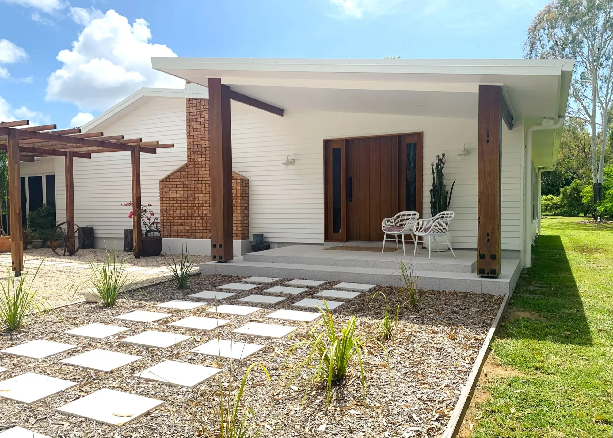 A completed JKC custom home — the entry, verandah posts and garden at dusk